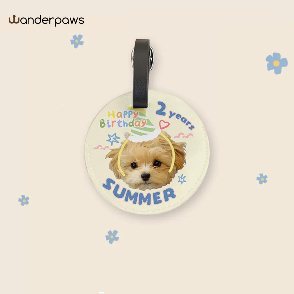 Cream round personalized pet photo luggage tag with a birthday design featuring a small tan dog
