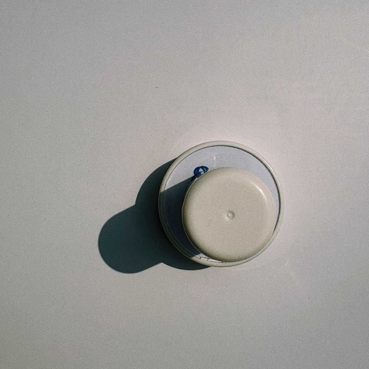 Top view of the white personalized pet portrait stamp and its circular base