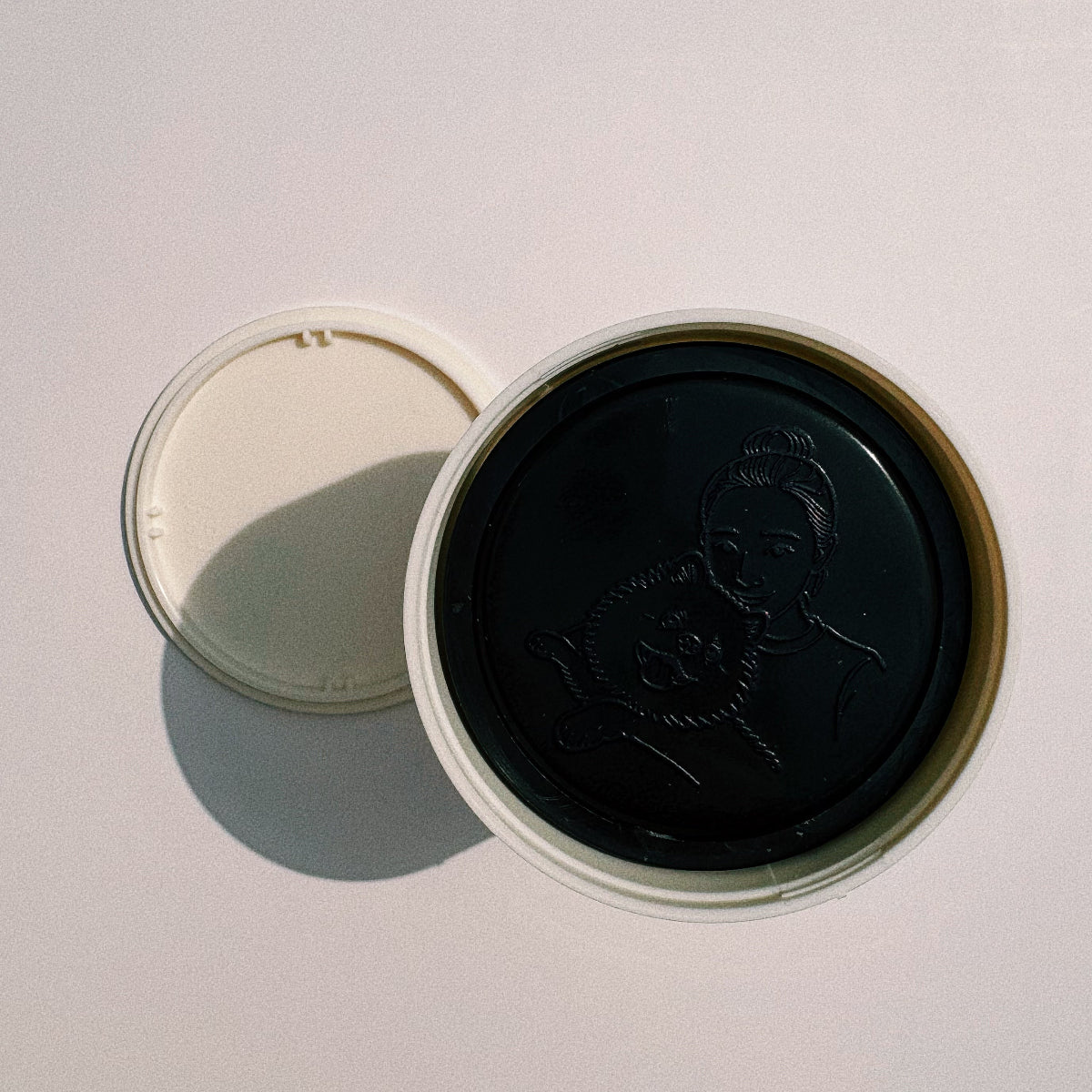 Open round stamp base showing a custom line-art portrait of a woman holding her dog