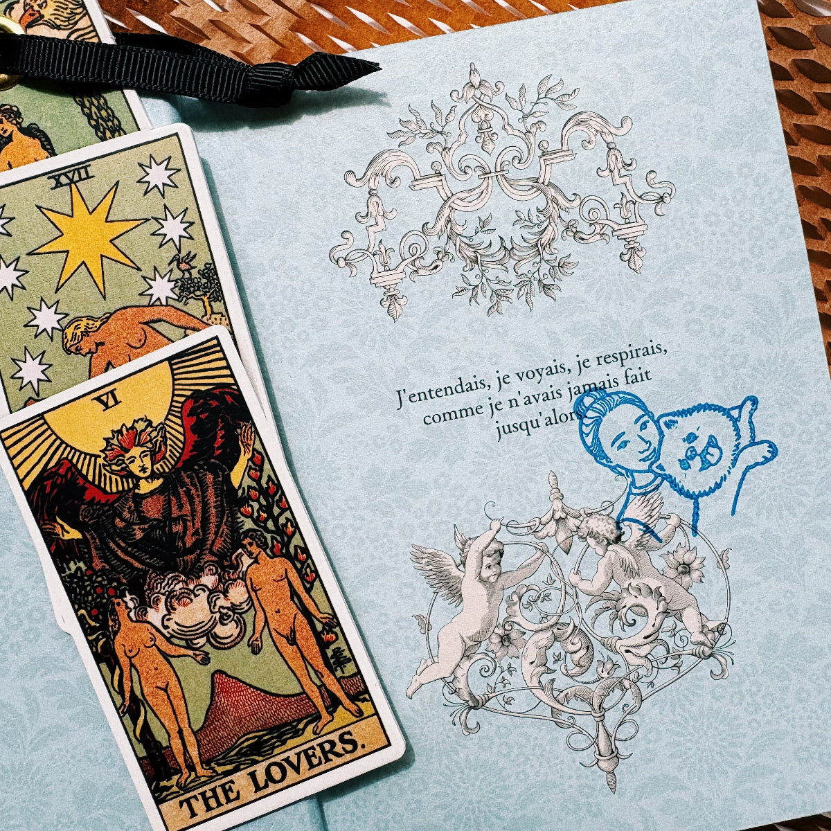 Blue personalized pet portrait stamp impression on a patterned card beside tarot cards