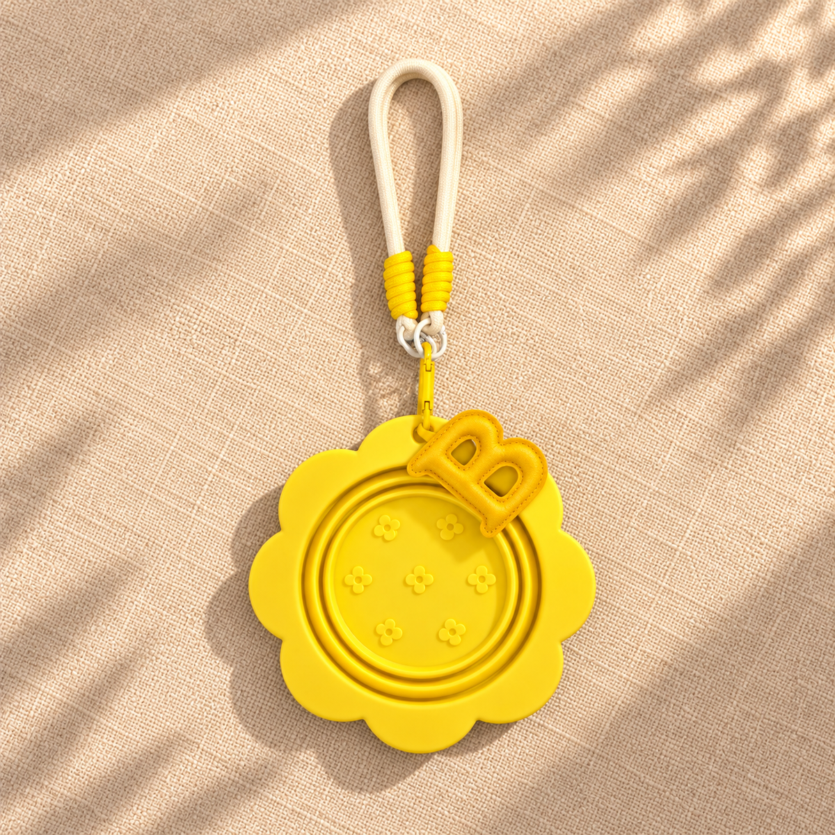 Folded sunny yellow pet travel bowl with matching hook, lanyard, and complimentary letter charm