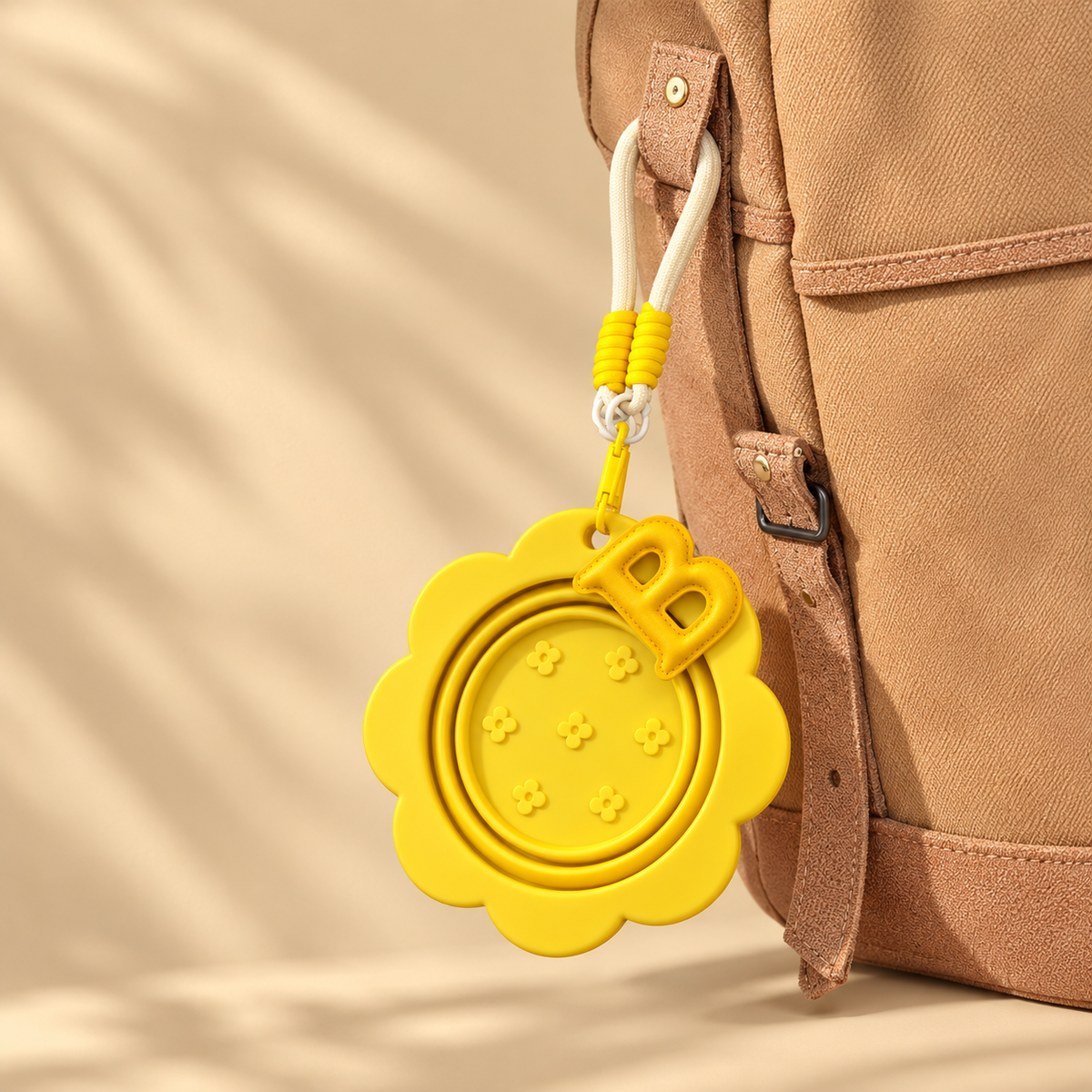 Folded yellow pet travel bowl attached to a backpack with its matching hook and lanyard