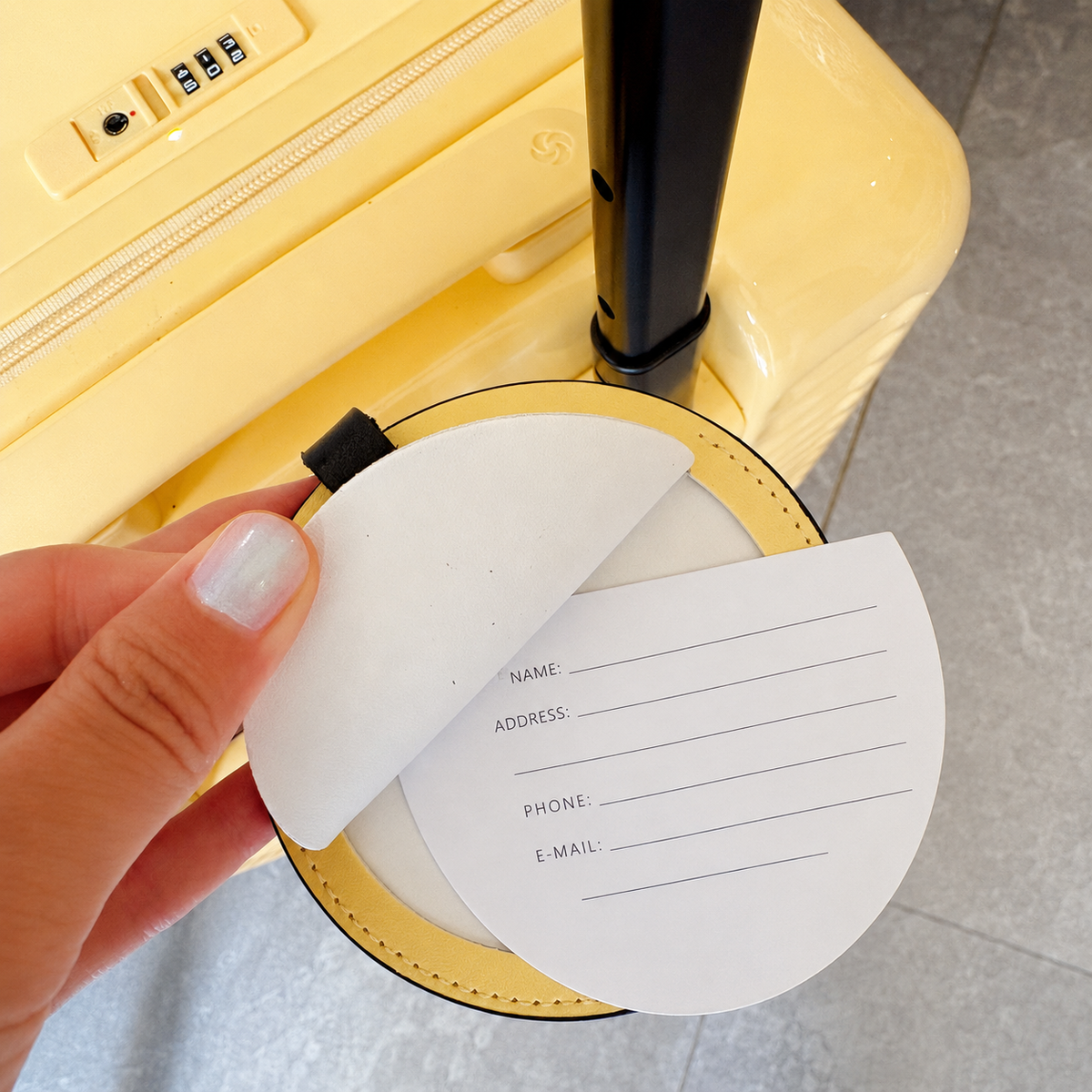 Back view of a yellow round personalized pet luggage tag printed with the pet name Xiongben